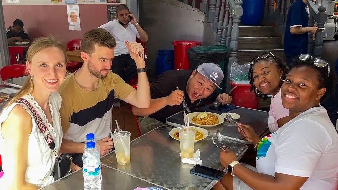 Group enjoying local cuisine at a street food stall during Bike and Bites Food Tour.