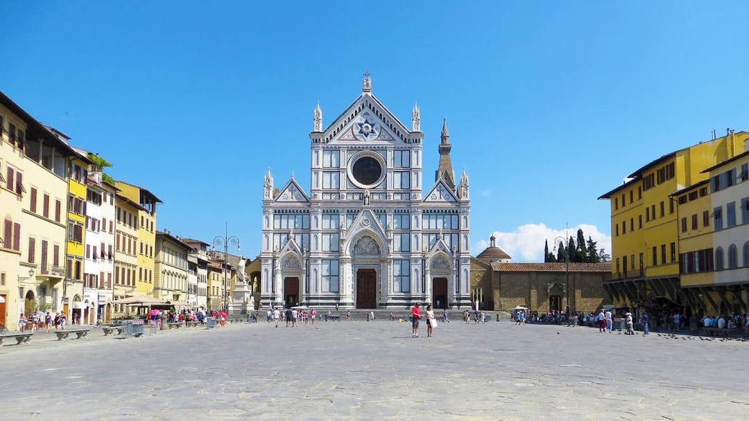 Basilica of Santa Croce in Florence with tourists in the square.