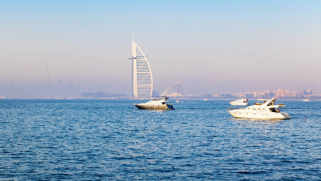 Boats on Dubai waters with Burj Al Arab in the background.