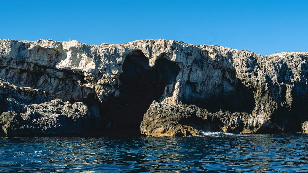 Sea cave entrance on Ortigia Island during sightseeing cruise.