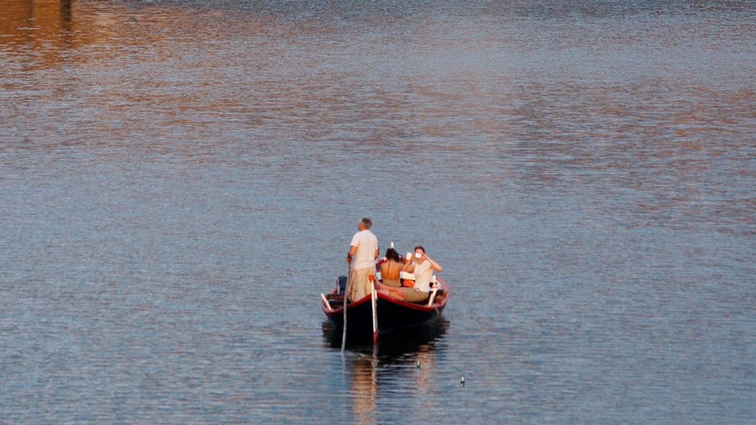 Guided boat tour on a Florentine gondola with tourists on a calm river.