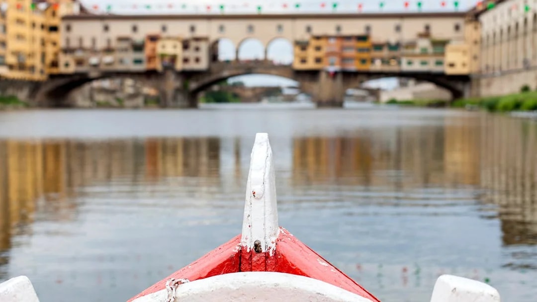Gondola approaching Ponte Vecchio on a guided boat tour in Florence.