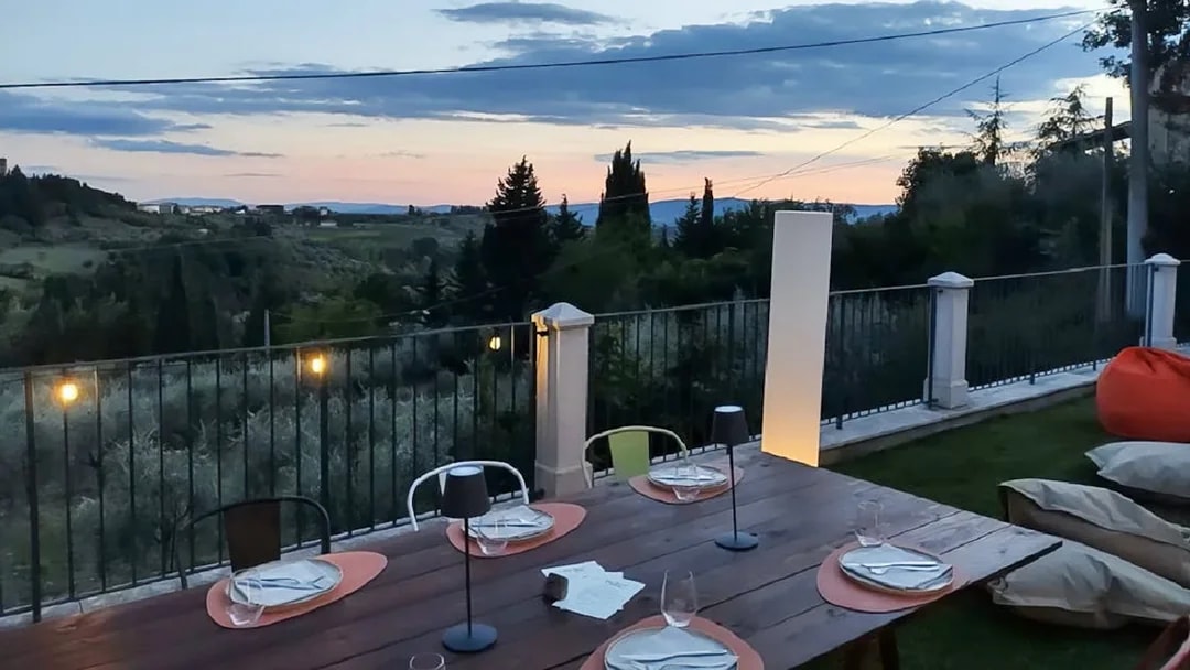 Outdoor dining setup overlooking Chianti hills at sunset during eBike tour.
