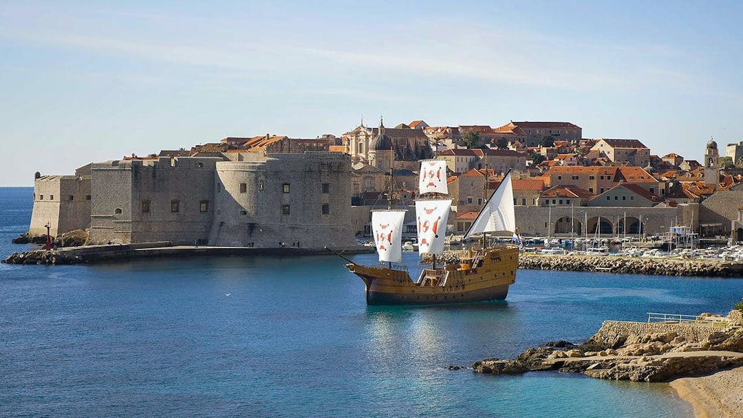 Sailing ship near Dubrovnik's historic city walls on Elaphite Islands cruise.