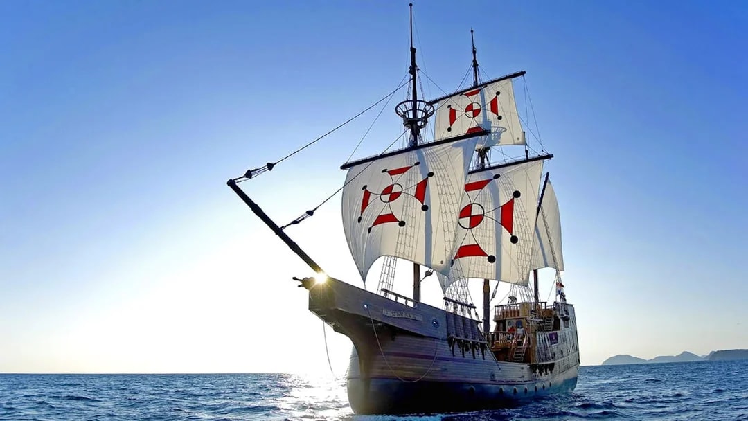 Sailing ship on Elaphite Islands cruise under clear blue sky.