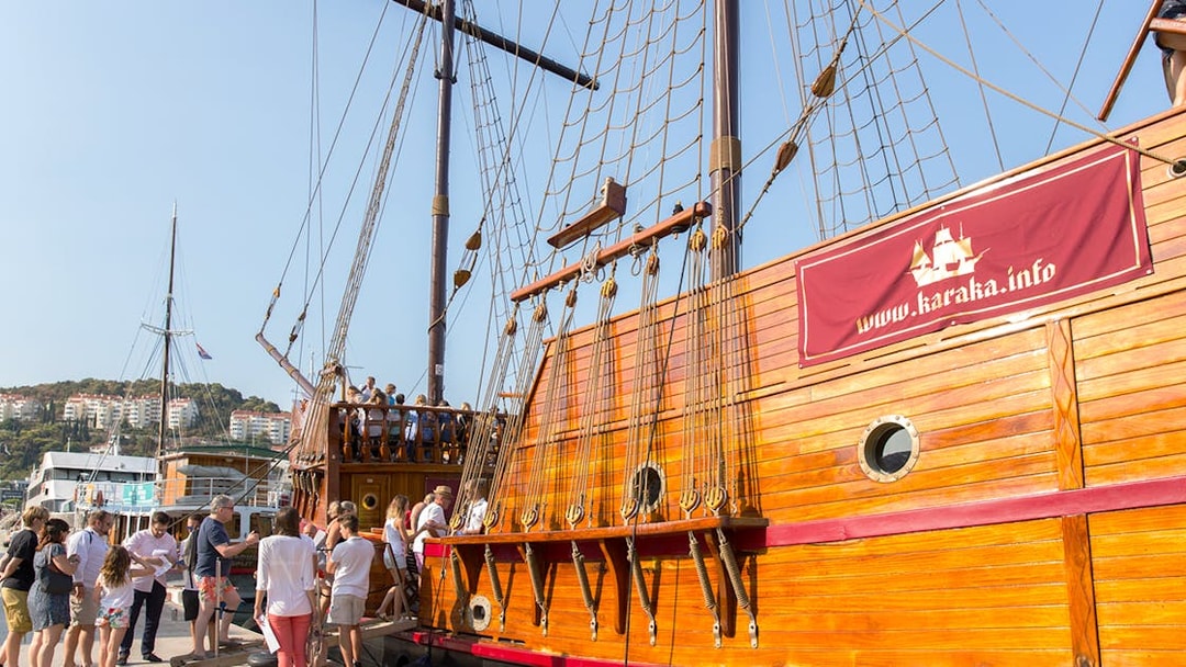 Tourists boarding a wooden ship for a guided Elaphite Islands cruise.