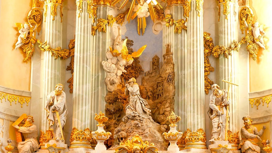 Frauenkirche interior with ornate sculptures and golden decorations on a guided gallery tour.