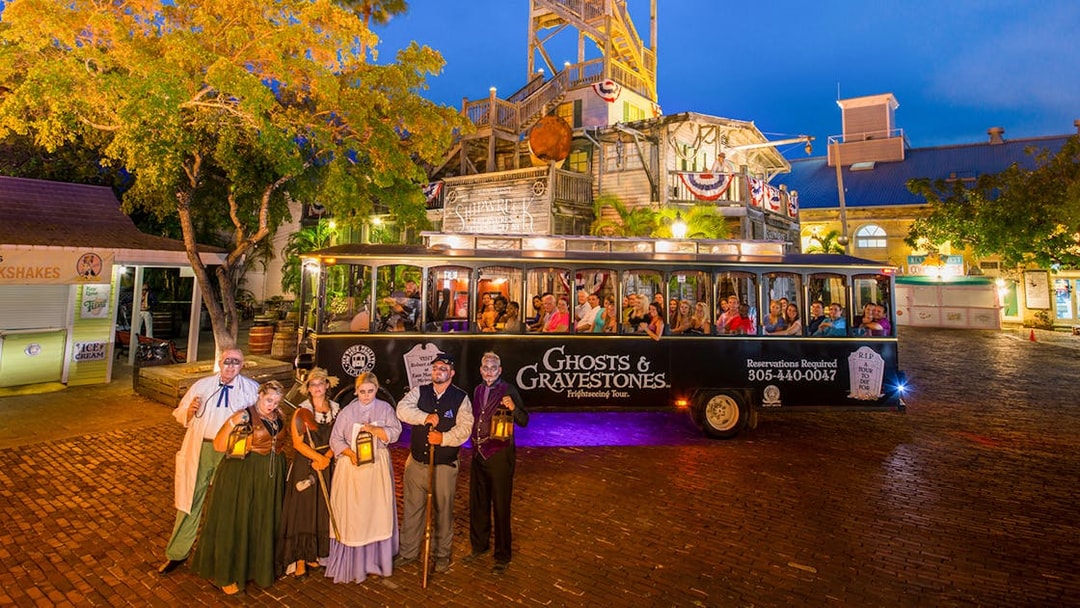 Ghosts & Gravestones tour trolley with costumed guides in Savannah at night.