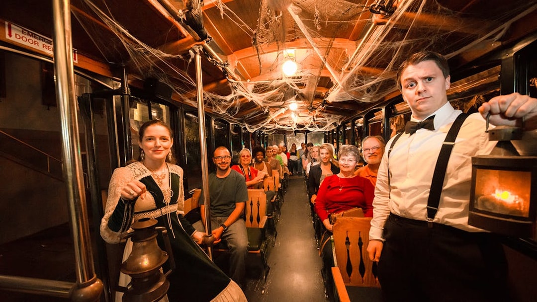 Tour group on Savannah's 'Ghosts & Gravestones' trolley, guides in period costumes.