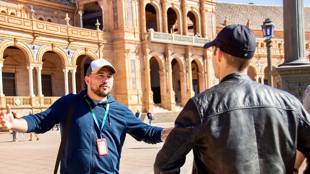 Tour guide explaining Plaza de España architecture during Seville walking tour.
