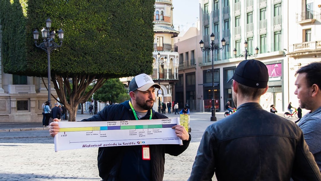 Guide explaining Seville's history to tourists with a timeline chart.