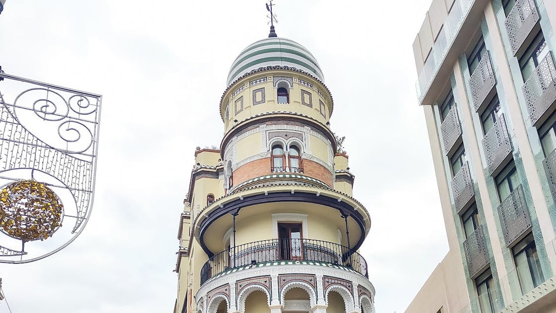 Historic building with ornate balconies on a walking tour in Seville.