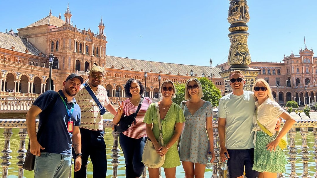 Tour group at Plaza de España, Seville, with historic architecture in the background.