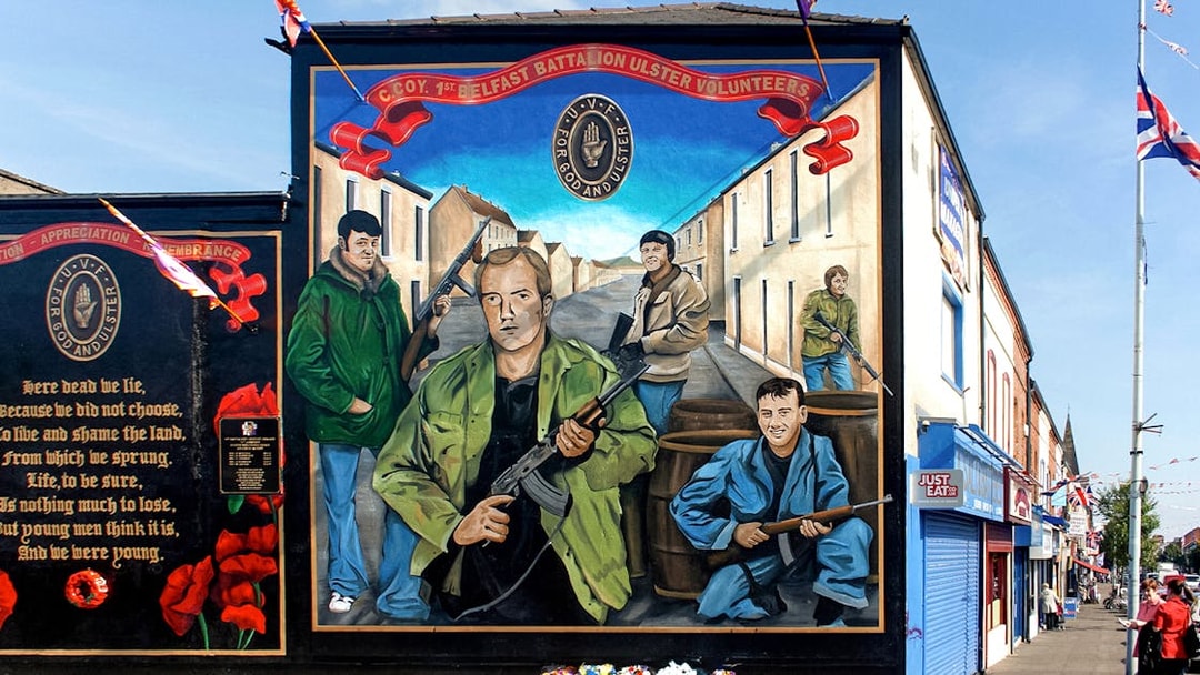 Belfast mural depicting Ulster Volunteer Force members on a street, part of a political taxi tour.