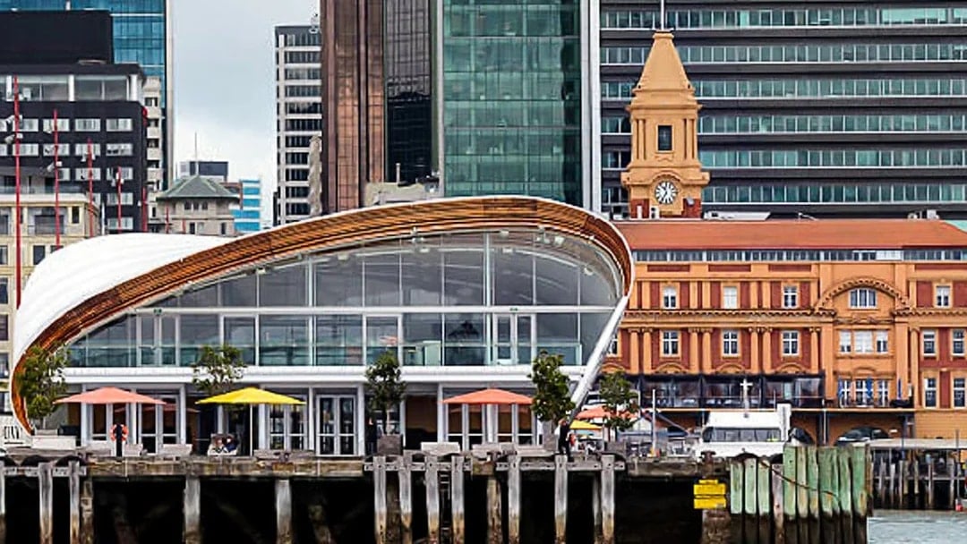 Auckland waterfront with modern architecture and historic ferry building.