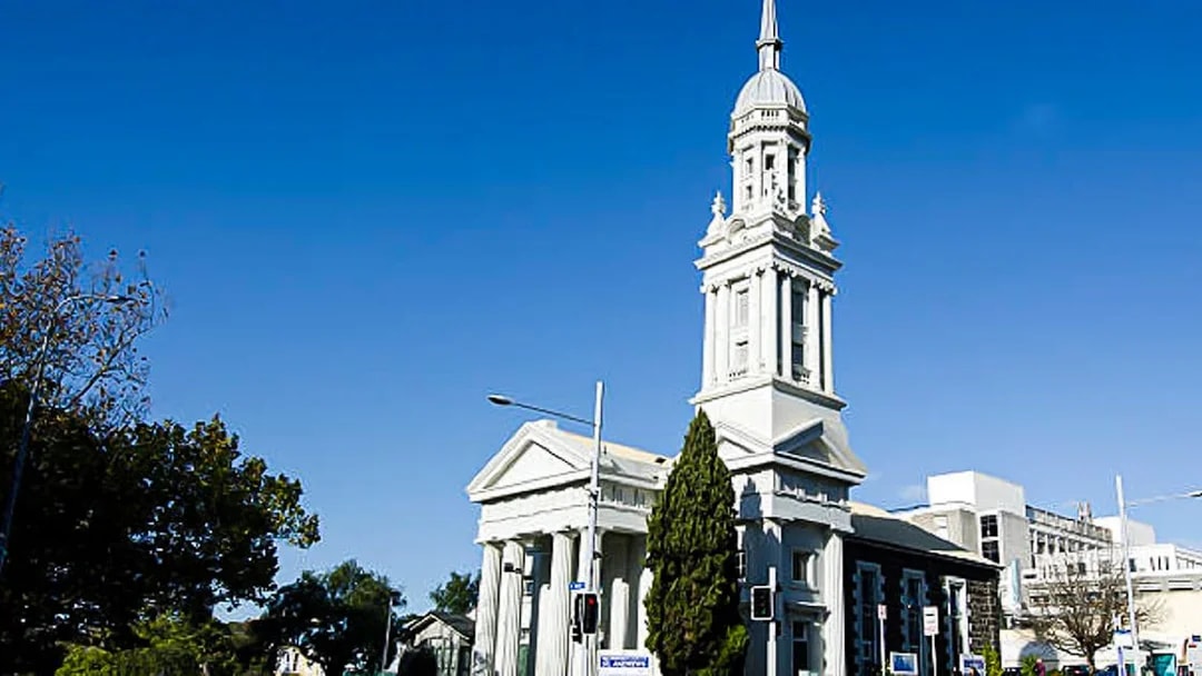 Historic church with tall spire on a street in Auckland, New Zealand.