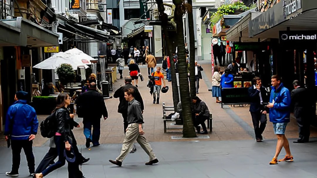 Pedestrians walking through a bustling street in Auckland during a guided small group tour.