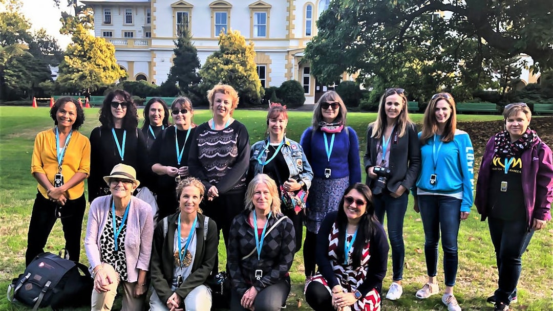 Group of tourists on a guided walking tour in front of a historic building in Auckland.