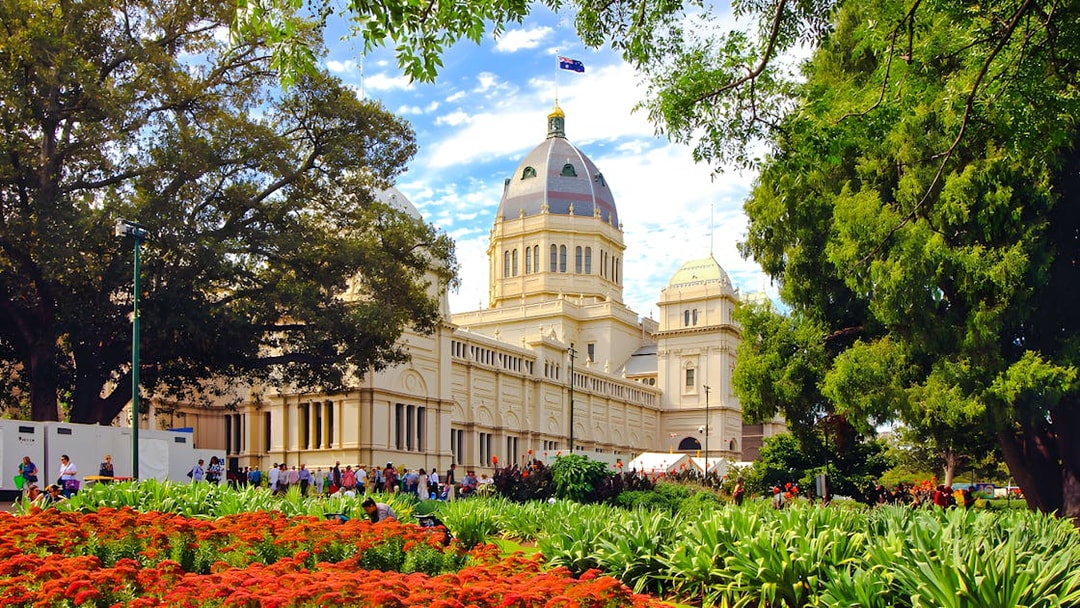 Royal Exhibition Building in Melbourne surrounded by gardens and trees.