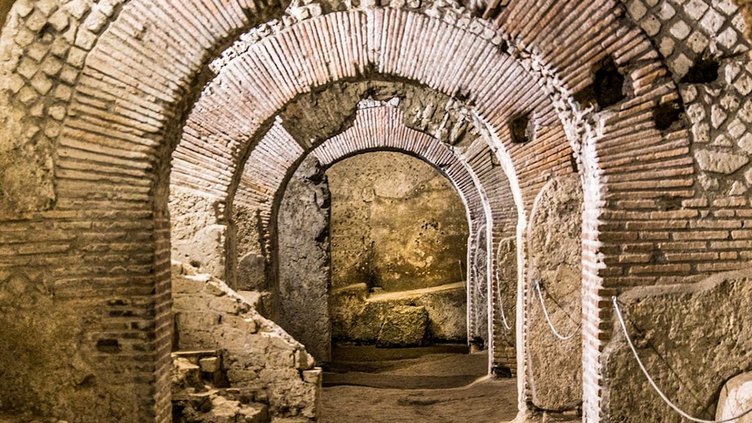 Underground ruins with ancient brick arches in Naples city tour.