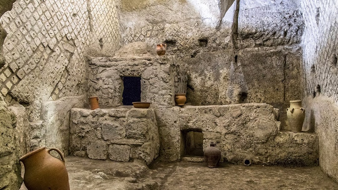 Underground ruins with ancient pottery in Naples city tour.