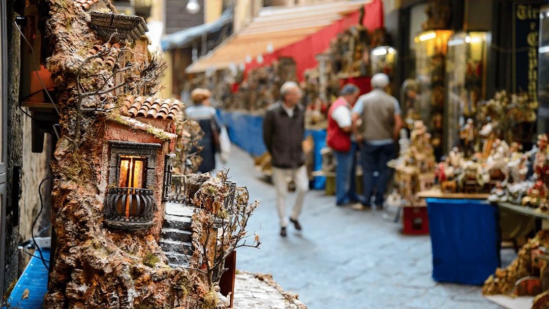 Street market in Naples with miniature house displays during guided tour.