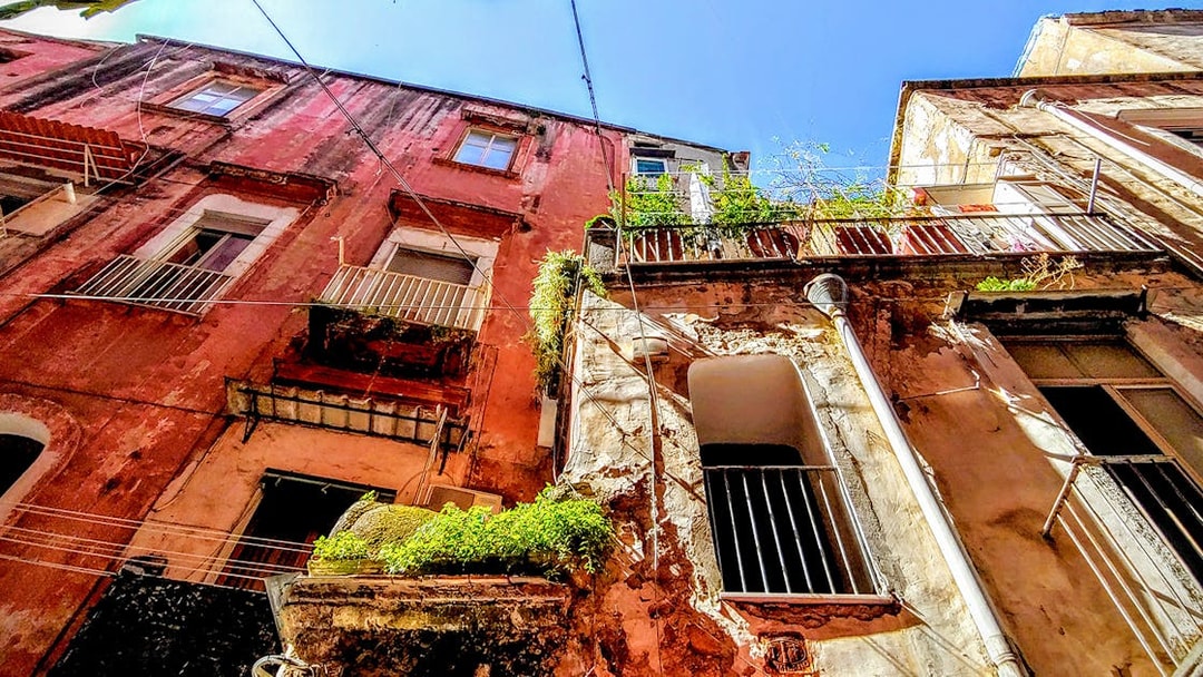 Old buildings with balconies in Naples, Italy, viewed from below on a sunny day.