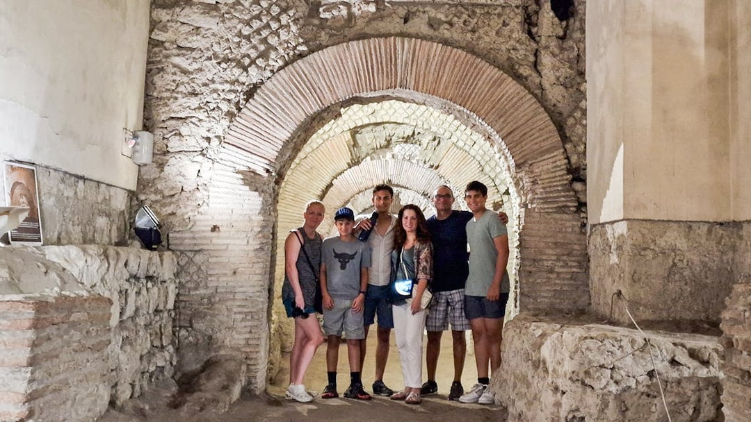 Tourists exploring Napoli Sotterranea underground ruins in Naples.