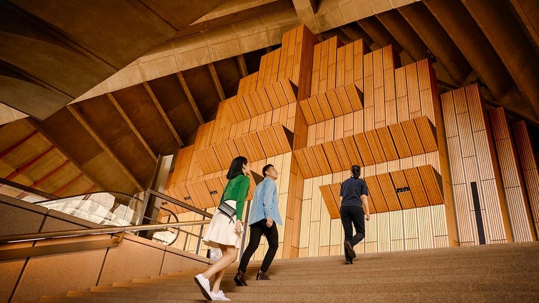 Visitors ascending steps inside Sydney Opera House during a guided tour.