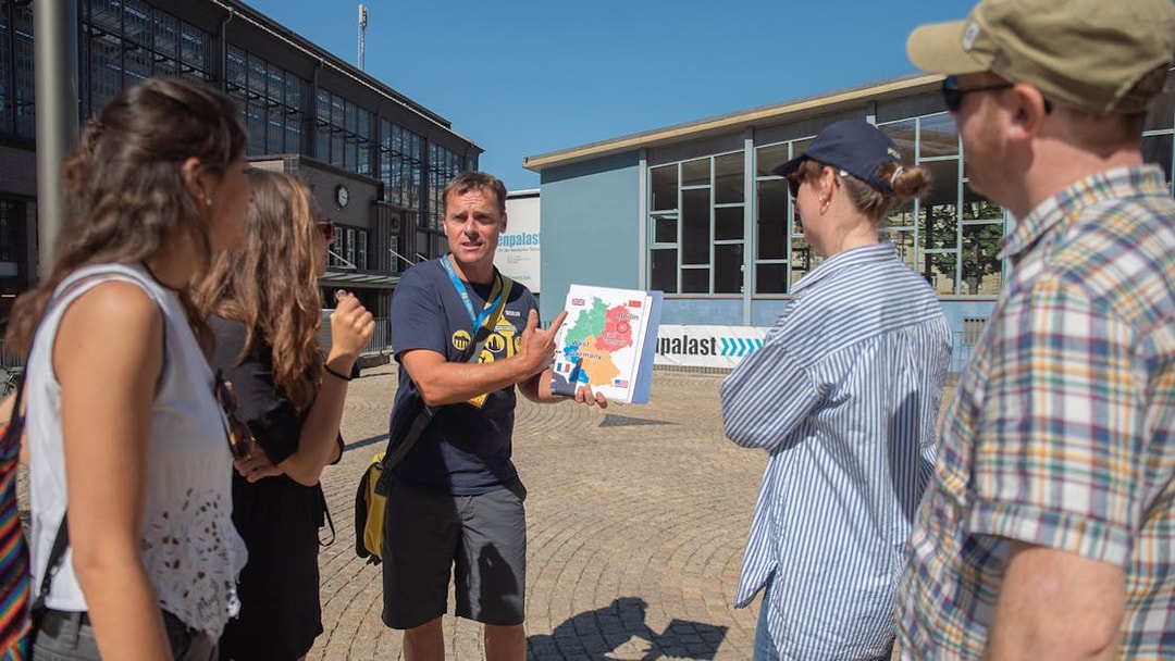 Tour guide explaining Cold War map to group in Berlin.