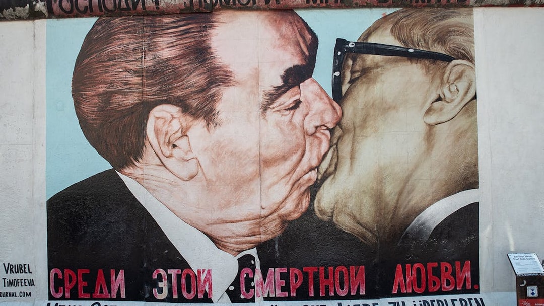Berlin Wall mural depicting a famous Cold War-era embrace, part of the East Side Gallery tour.
