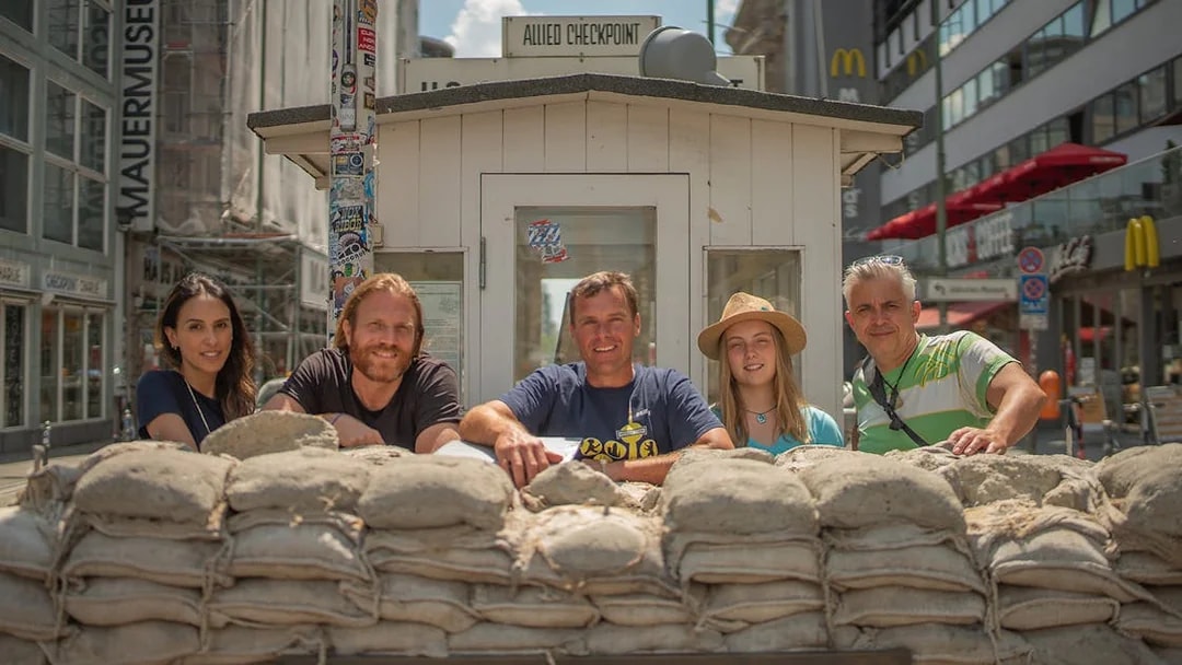 Tourists at Checkpoint Charlie in Berlin during a Cold War guided tour.