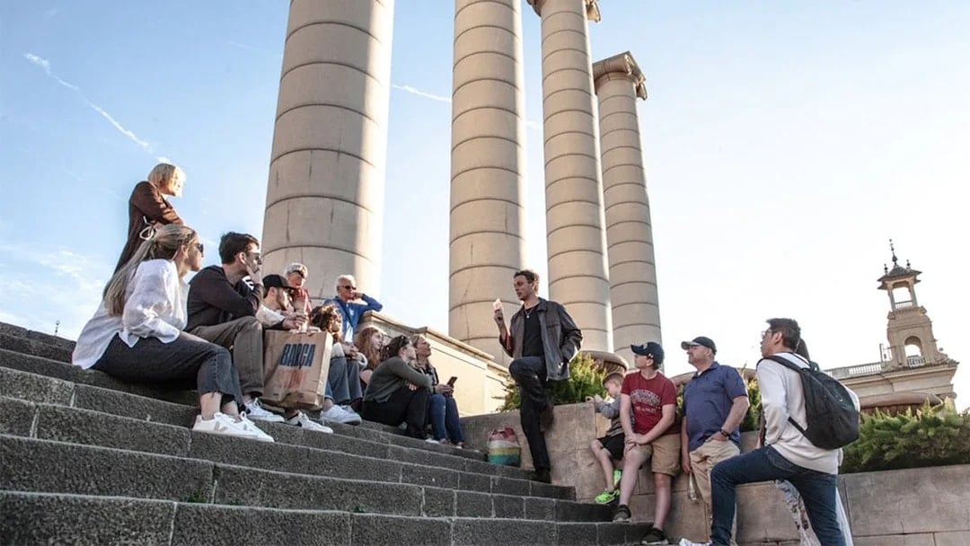 Group listening to a guide near Montjuïc columns in Barcelona.