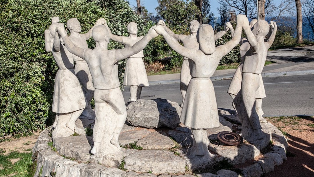Stone sculpture of people dancing in a circle on Montjuïc, Barcelona.