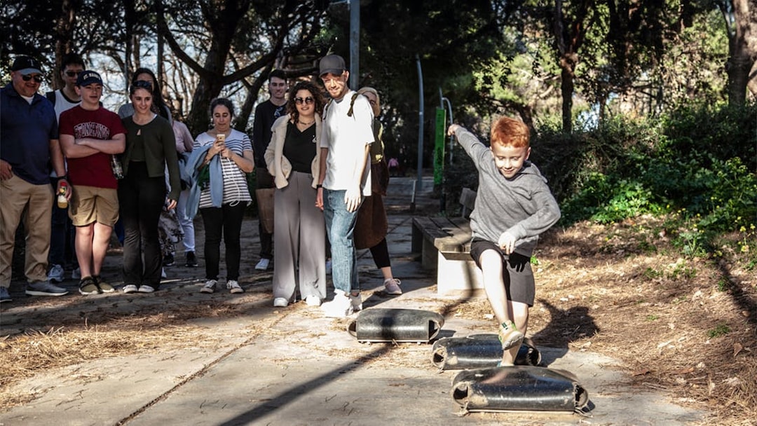 Group watching a child play during a guided walking tour of Montjuïc.