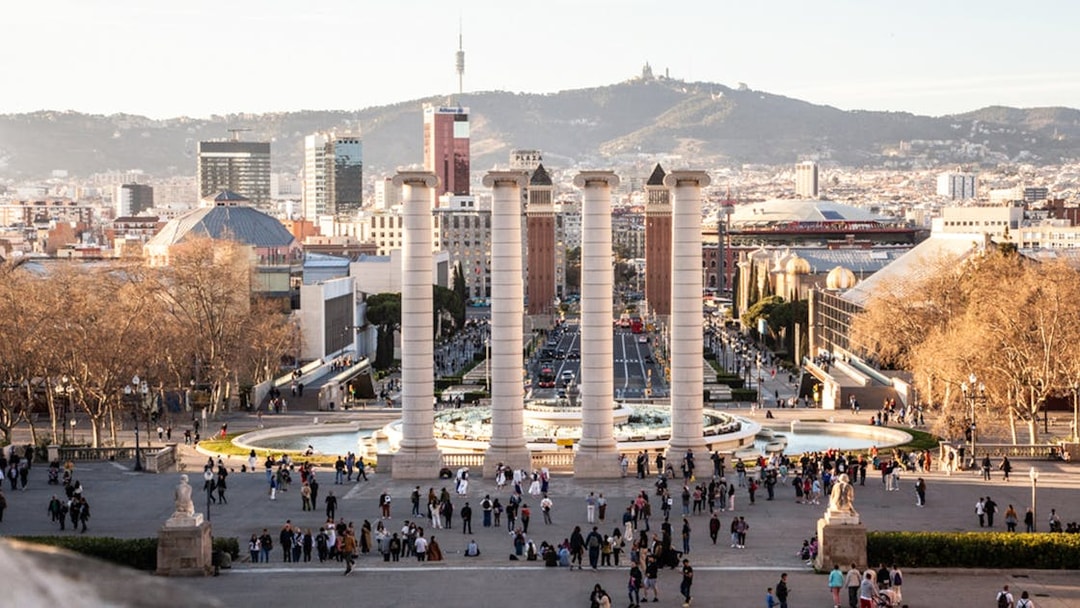 Montjuïc view with four columns and cityscape in Barcelona during guided walking tour.