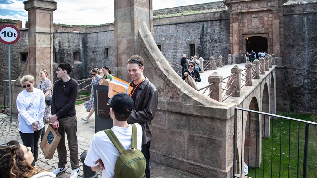 Tour group exploring Montjuïc Castle entrance on a guided walking tour.