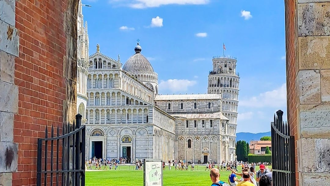 Pisa Cathedral and Leaning Tower viewed through an archway during a guided walking tour.
