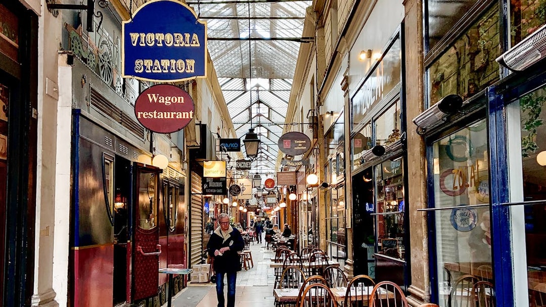 Guided walking tour through the covered passages of Paris with shops and cafes.
