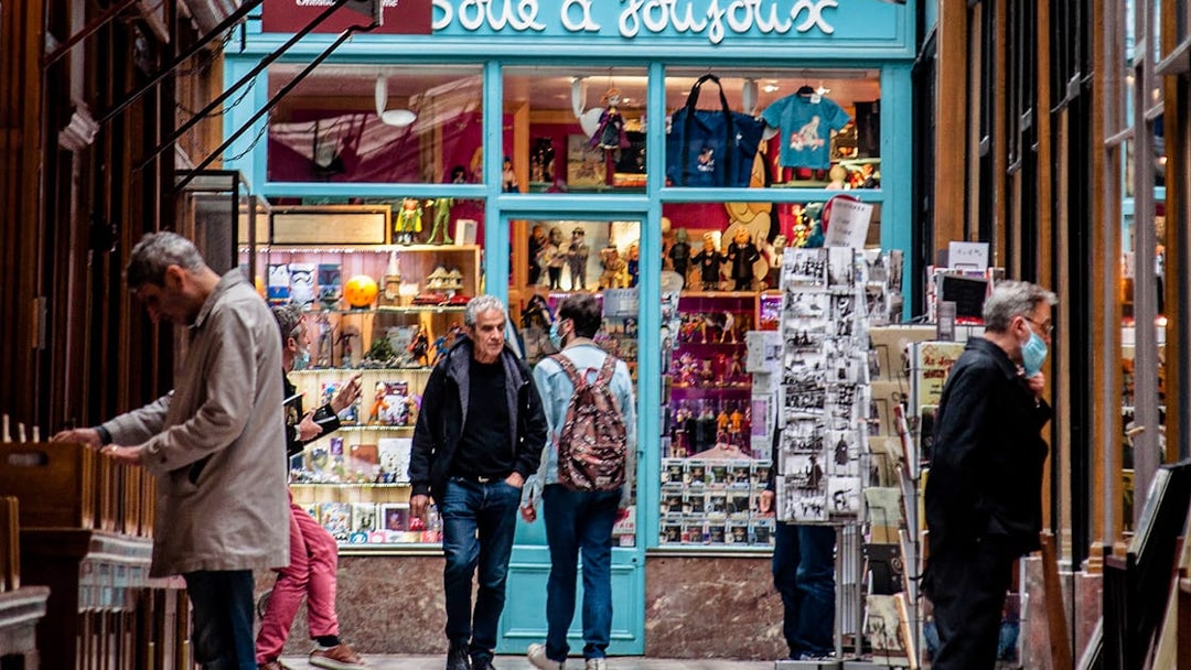 Shoppers explore a toy store in a Parisian covered passage.