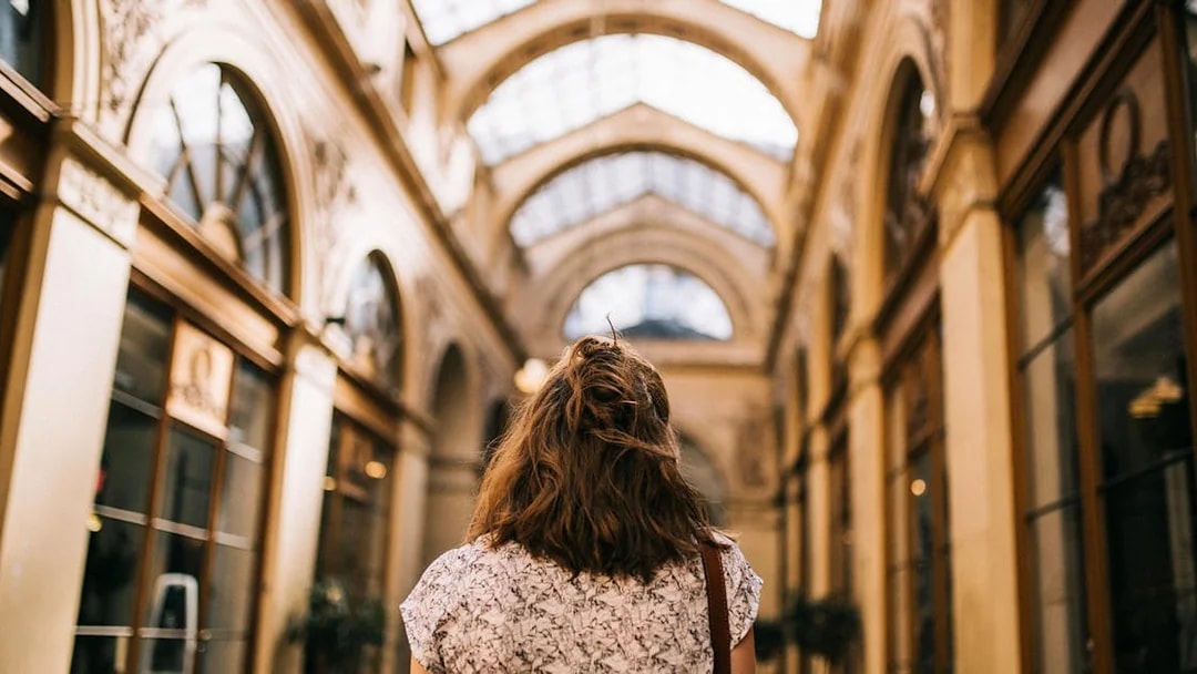 Walking through a covered passage in Paris during a guided tour.