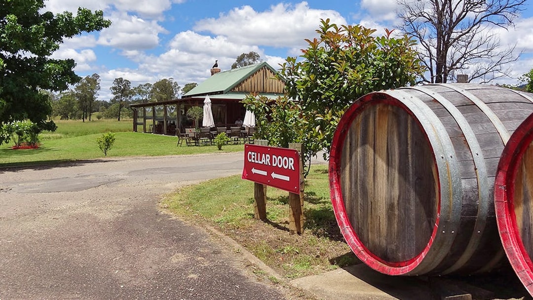 Cellar door sign and wine barrels at a vineyard in Hunter Valley.