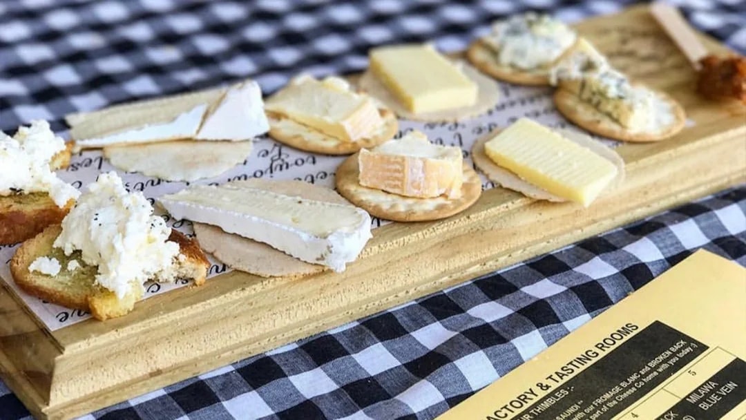 Cheese platter with various cheeses on crackers, part of a Hunter Valley wine tasting tour.