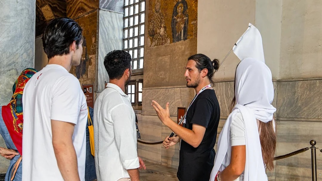 Tour guide explaining mosaics to visitors inside Hagia Sophia, Istanbul.