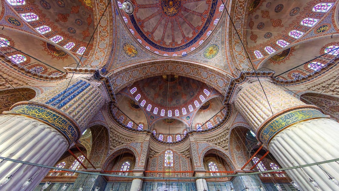 Interior view of The Blue Mosque's ornate dome and columns in Istanbul, Turkey.