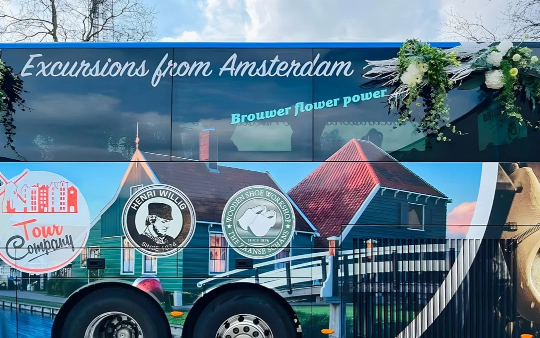 Roundtrip AC coach with Amsterdam tour branding and scenic imagery.