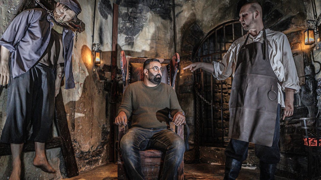Torturer scene with actor and visitor inside Hamburg Dungeon.