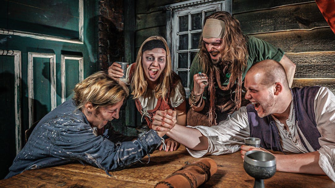 Visitors arm wrestling in a themed room at Hamburg Dungeon.