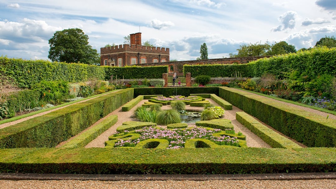 Visitors in Pond Gardens at Hampton Court Palace on a sunny day.