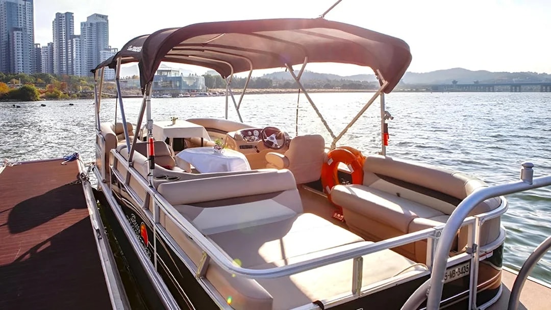 Yacht docked at Han River Marina, Seoul, with city skyline in the background.